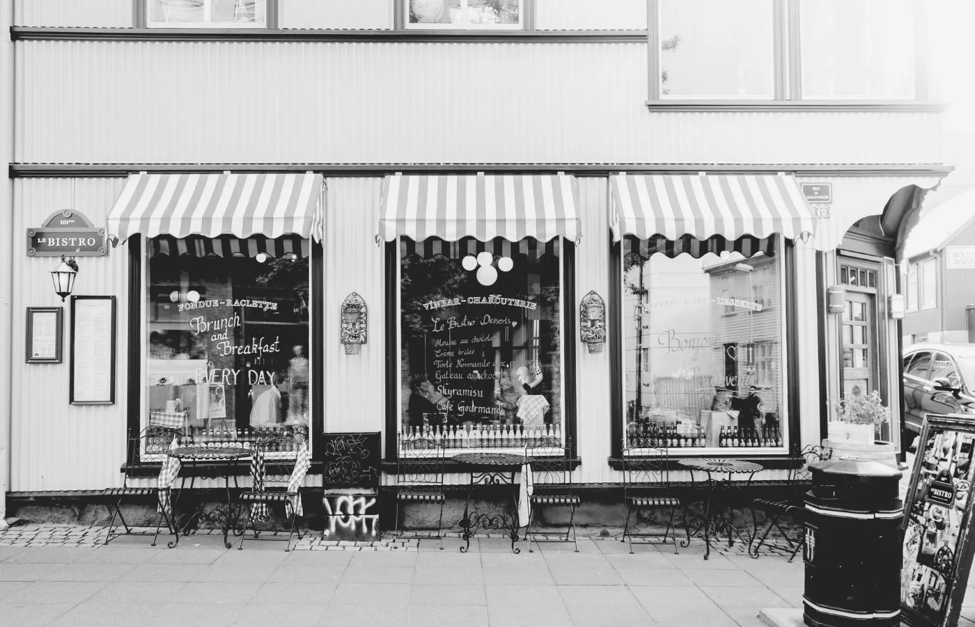 Coffee bar con vetrine che danno sulla strada con scritte in gesso bianco del menù e altri messaggi promozionali